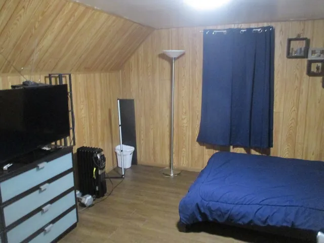 a bedroom with a bed window and television