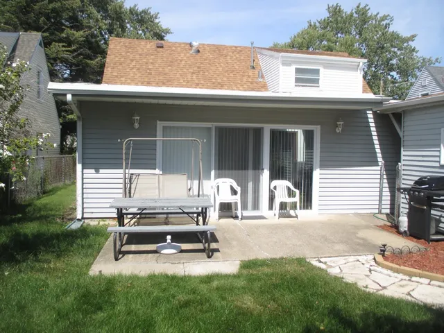 a view of a house with backyard porch and sitting area