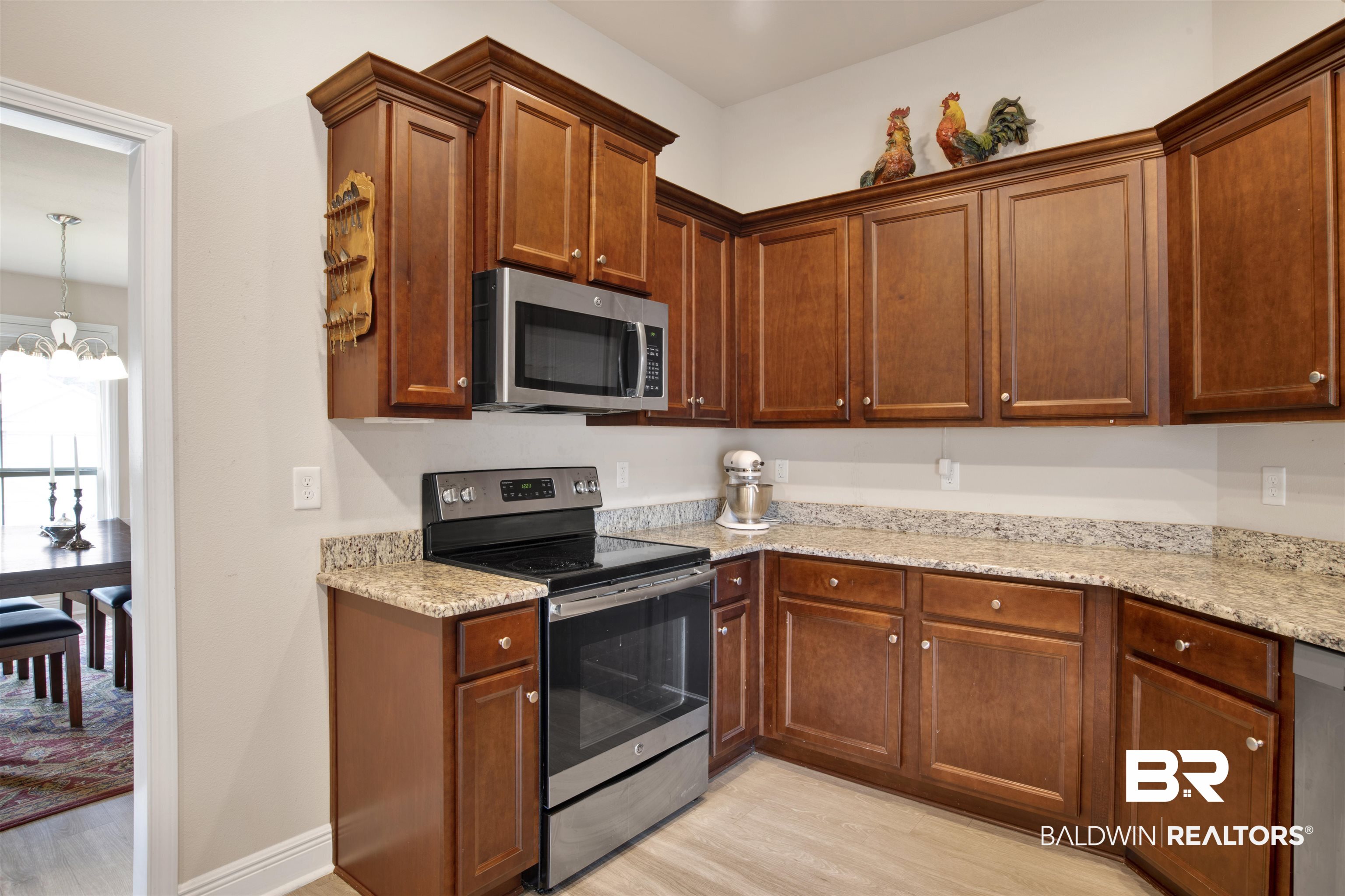22056 Garland Loop Silverhill, AL 36576 - Photo 7 of 28 Kitchen with light wood finished floors, an inviting chandelier, light stone countertops, and appliances with stainless steel finishes