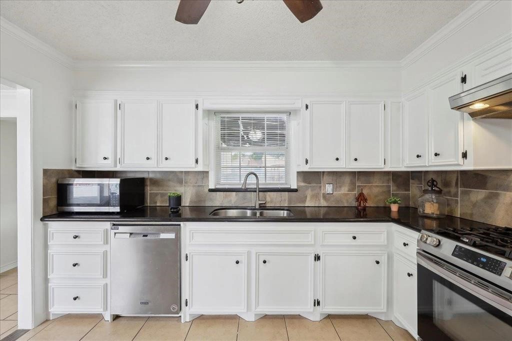 253 Hampton Lane Beaumont, TX 77707 - Photo 12 of 33 a kitchen with white cabinets stainless steel appliances and sink