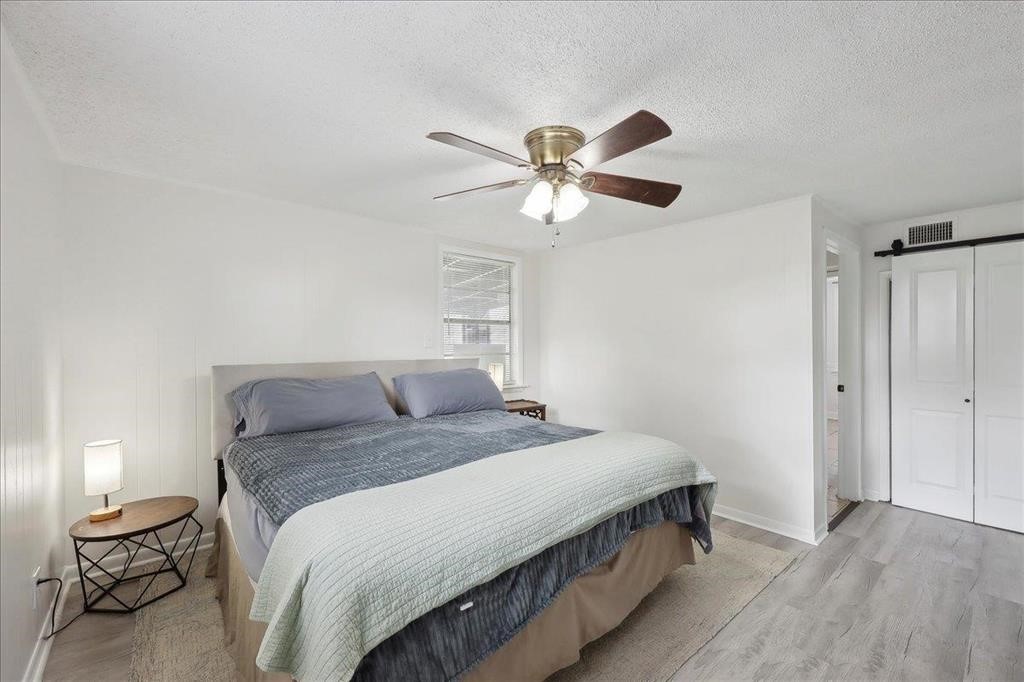 253 Hampton Lane Beaumont, TX 77707 - Photo 13 of 33 a bedroom with a bed and a chandelier
