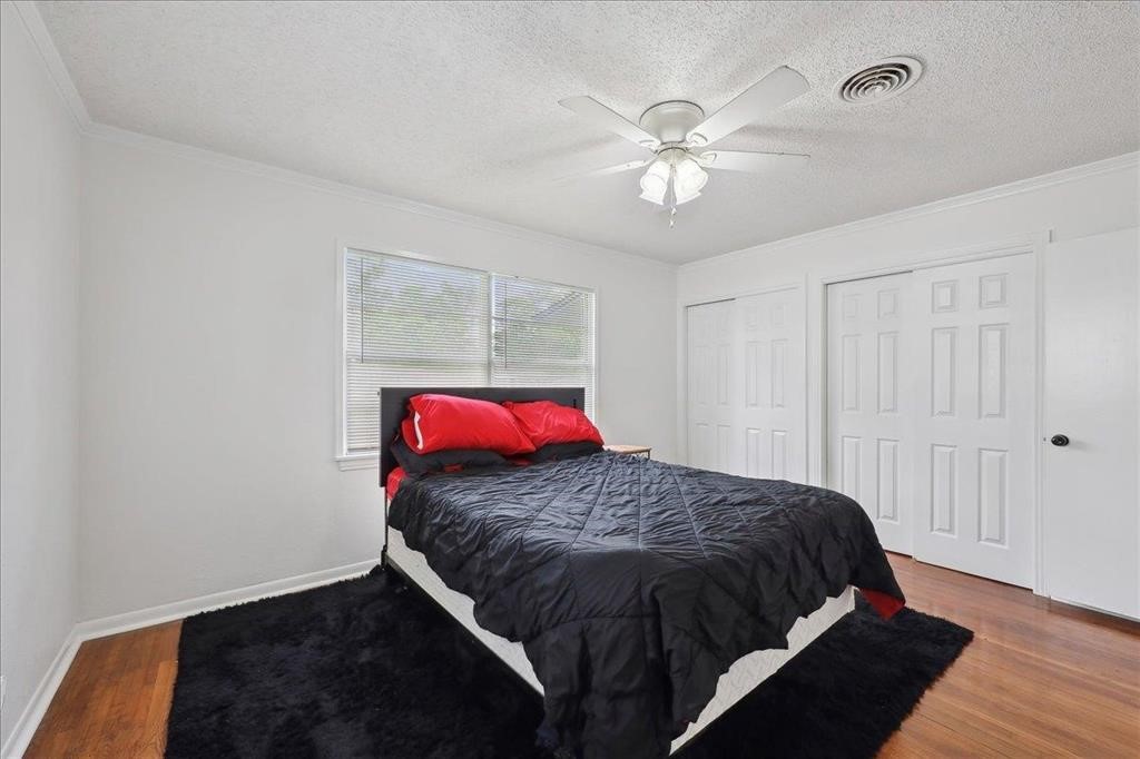 253 Hampton Lane Beaumont, TX 77707 - Photo 19 of 33 a bedroom with a bed and a chandelier