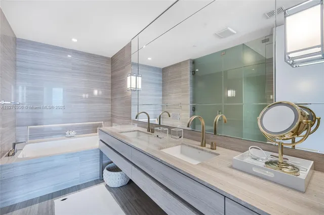 a bathroom with a granite countertop sink a mirror and a bathtub