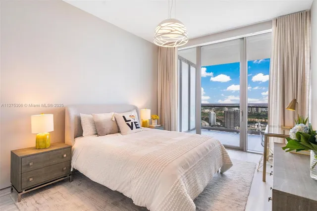 a bedroom with a bed and a large window