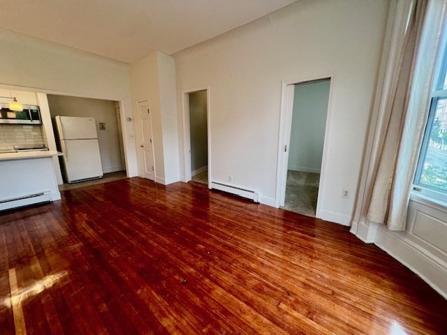 591 Beacon Street, Unit 3 Boston, MA 02215 - Photo 3 of 8 a view of an empty room with wooden floor and a window