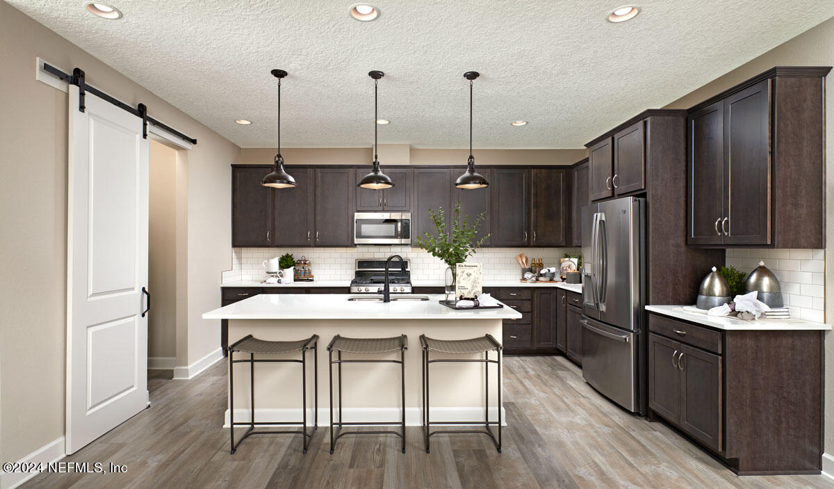 619 Bartram Downs Road Orange Park, FL 32065 - Photo 5 of 6 a kitchen with a table chairs refrigerator and microwave