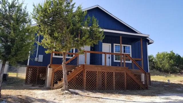a view of a house with large windows and a small yard
