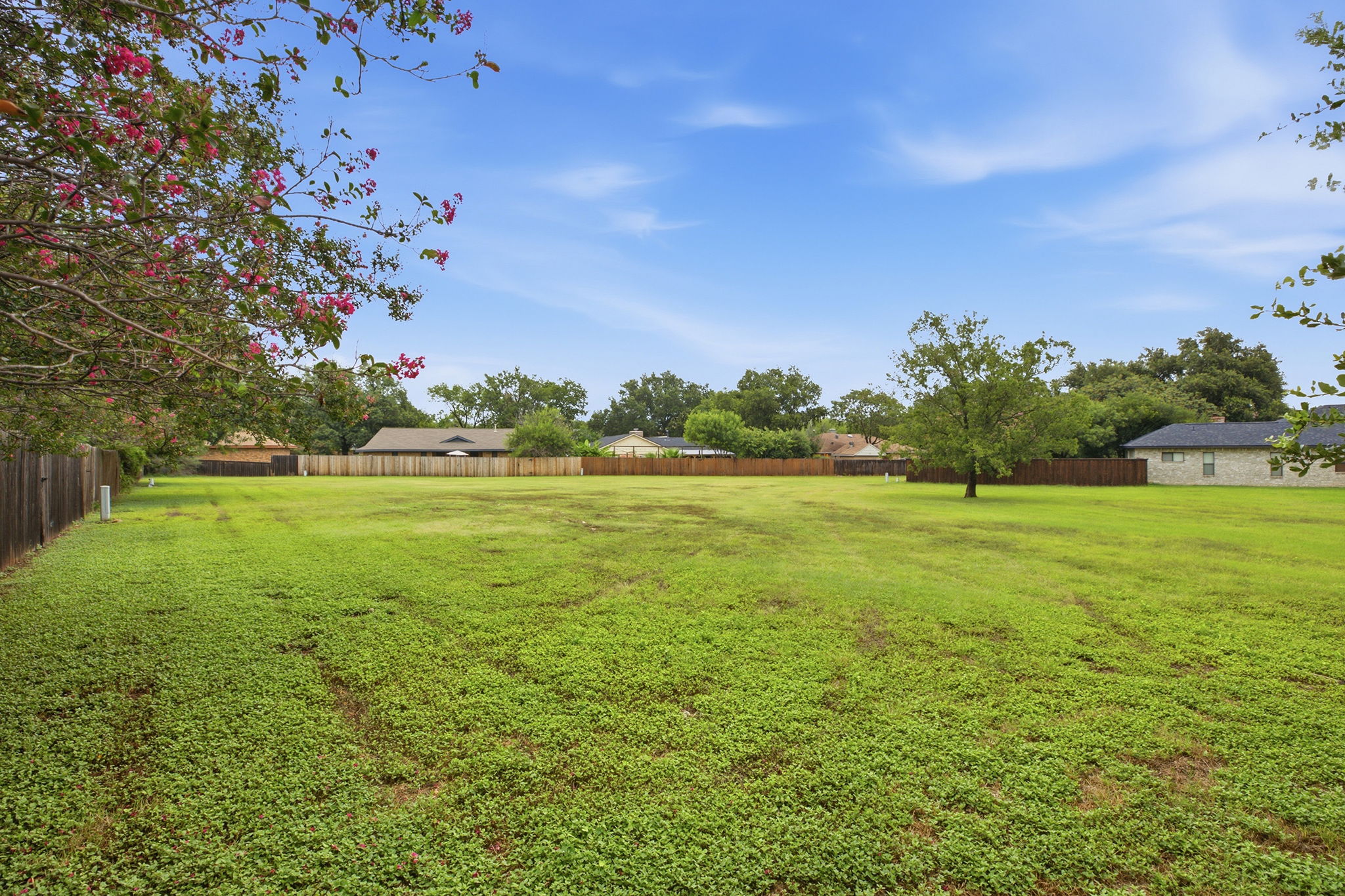 7205 Beckett Road Austin, TX 78749 - Photo 36 of 40 A spacious, verdant lot awaits your vision, bordered by a classic wooden fence and mature trees.