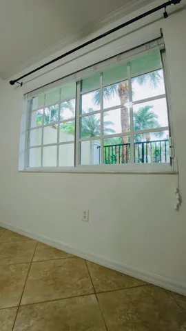 a view of an empty room and kitchen with a sink