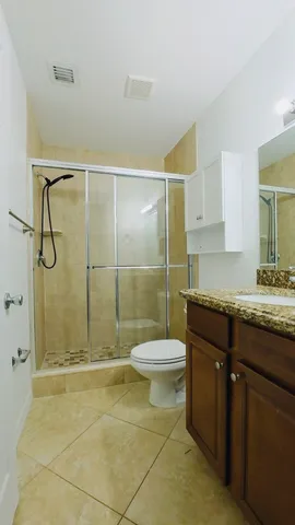 a bathroom with a granite countertop sink toilet and a shower