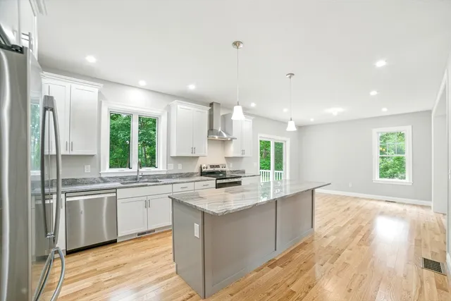 a large kitchen with a large counter top sink stainless steel appliances and cabinets