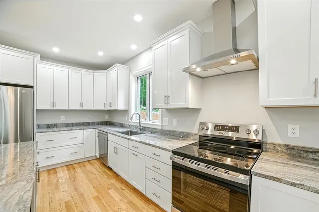 a kitchen with granite countertop a sink stainless steel appliances and cabinets