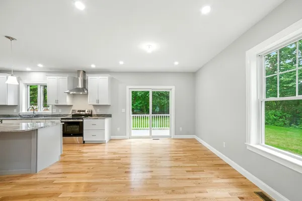 a large kitchen with stainless steel appliances granite countertop a stove a sink and a window