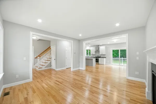 a view of empty room with wooden floor and fireplace