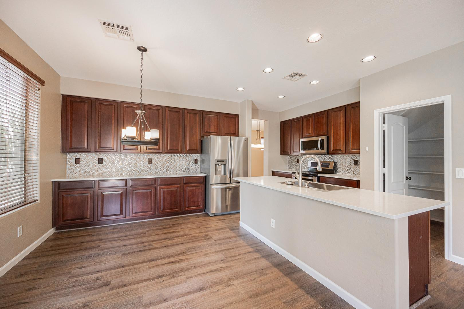 6539 West Jomax Road Phoenix, AZ 85083 - Photo 6 of 39 a large kitchen with kitchen island a sink a center island and stainless steel appliances