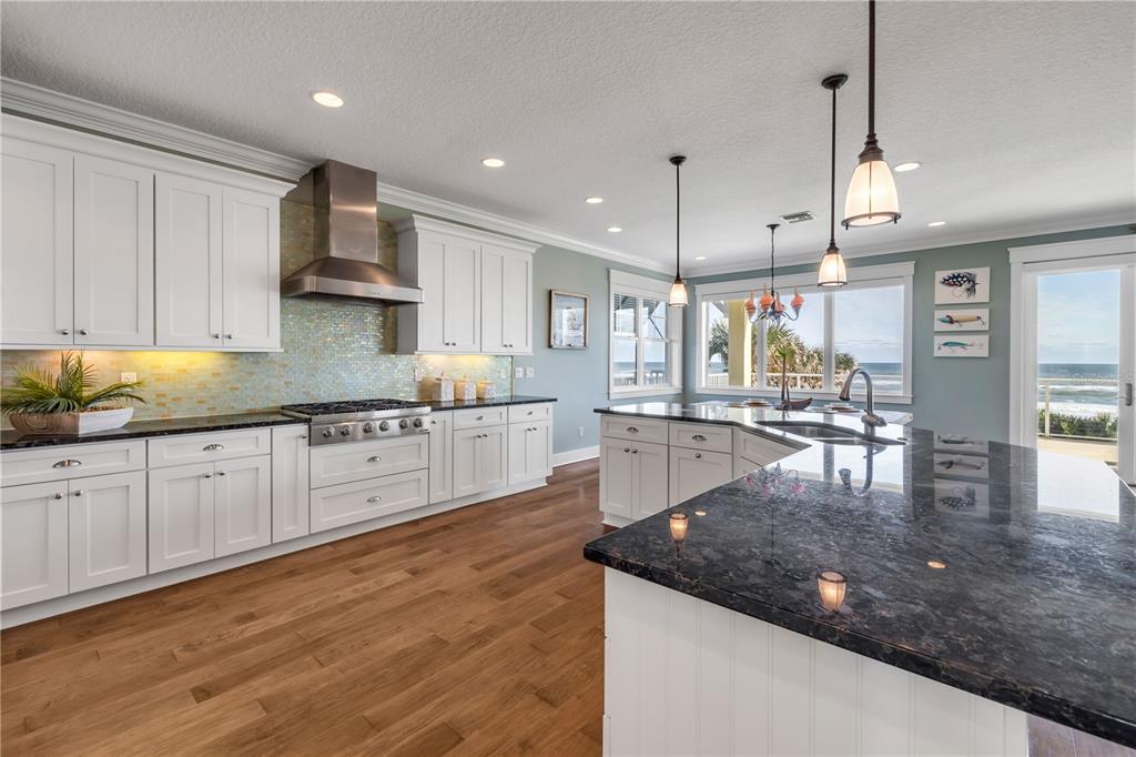 6101 Turtlemound Road New Smyrna Beach, FL 32169 - Photo 11 of 82 a kitchen with stainless steel appliances granite countertop a sink refrigerator and cabinets