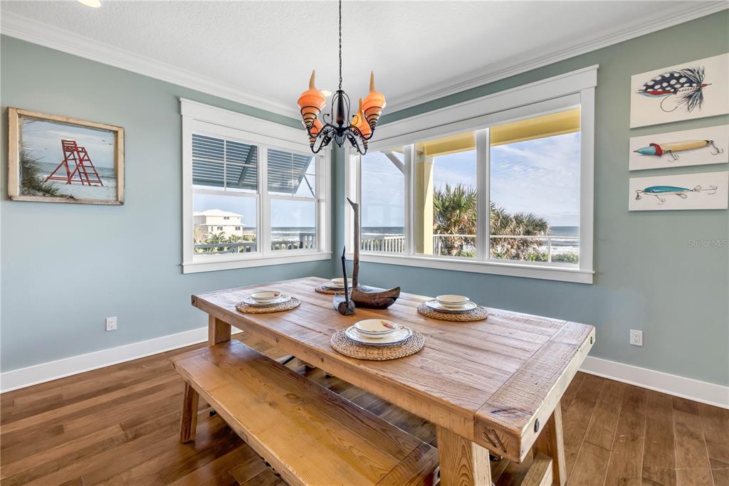 6101 Turtlemound Road New Smyrna Beach, FL 32169 - Photo 17 of 82 a view of a dining room with furniture a chandelier and wooden floor