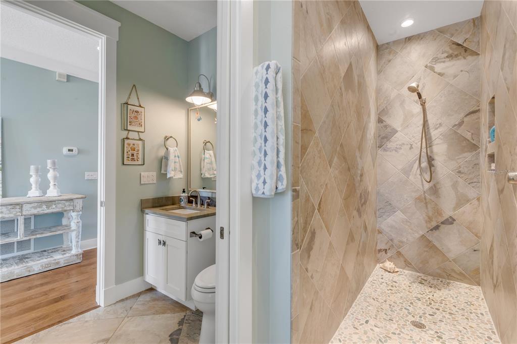 6101 Turtlemound Road New Smyrna Beach, FL 32169 - Photo 37 of 82 a bathroom with a sink a mirror and a shower