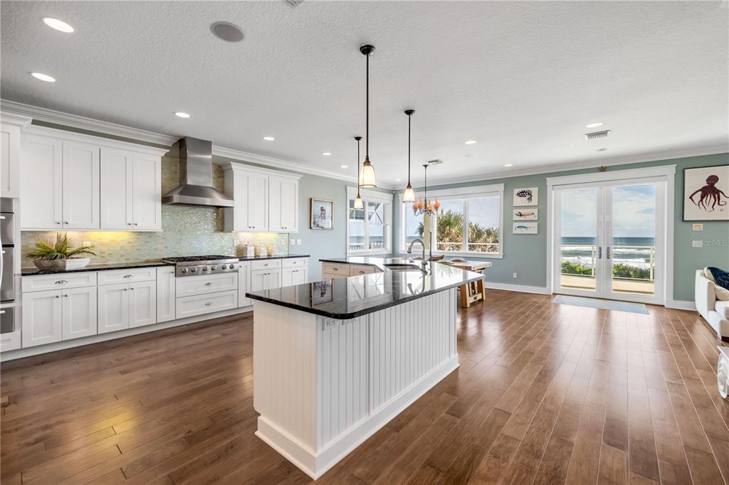 6101 Turtlemound Road New Smyrna Beach, FL 32169 - Photo 9 of 82 a large kitchen with stainless steel appliances granite countertop a lot of counter space and wooden floors