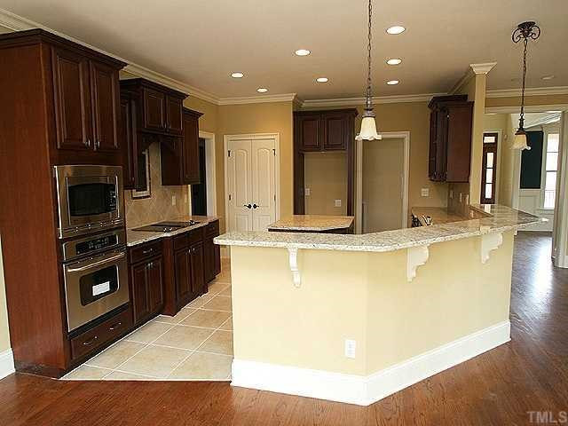 7315 Ridgeline Drive Raleigh, NC 27613 - Photo 3 of 8 a kitchen with kitchen island granite countertop wooden cabinets a oven and a sink