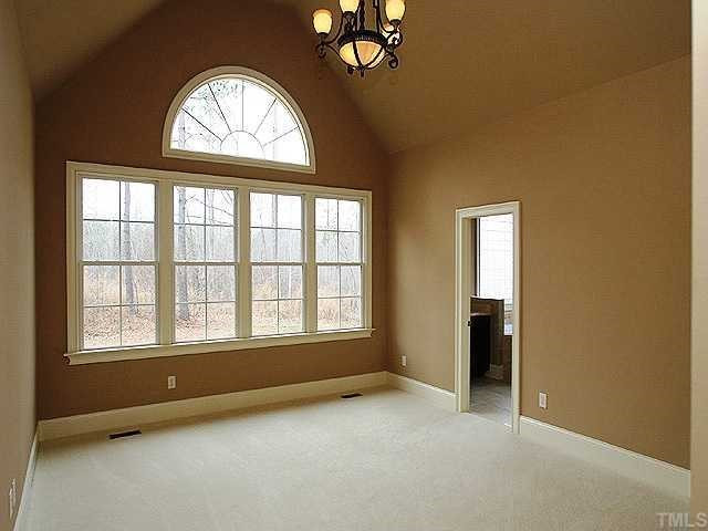 7315 Ridgeline Drive Raleigh, NC 27613 - Photo 5 of 8 an empty room with a fireplace and windows