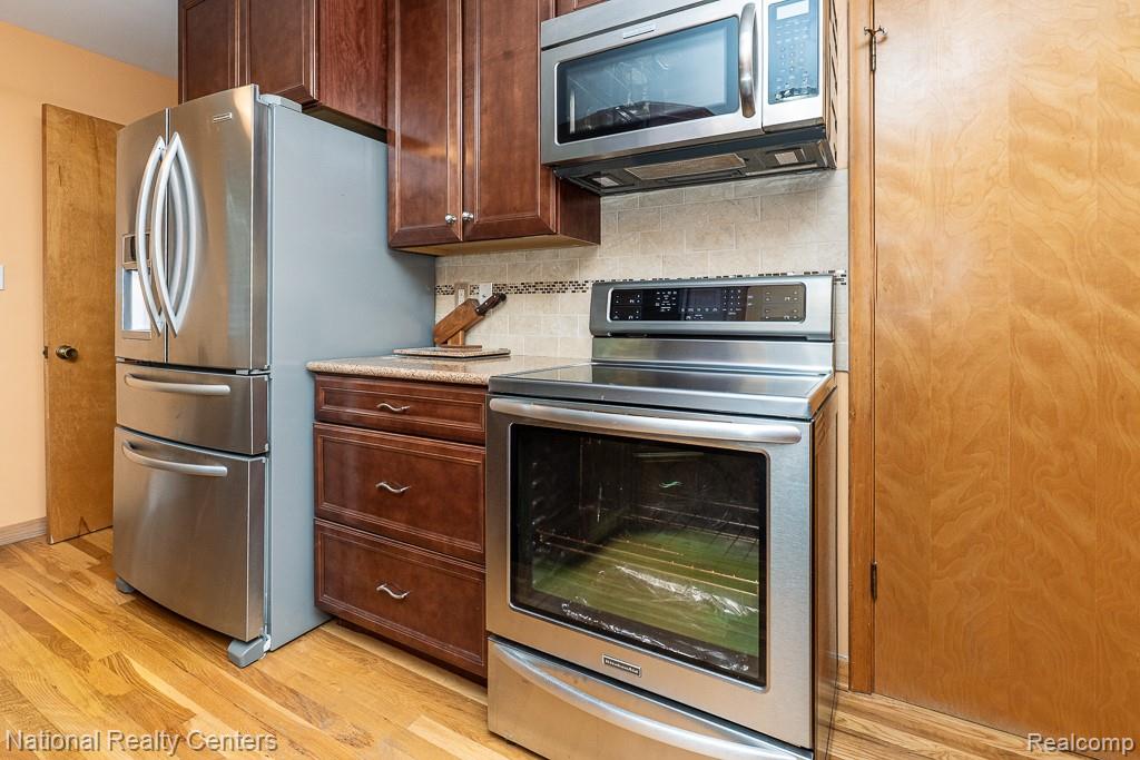 837 Dakota Court Rochester, MI 48307 - Photo 12 of 34 Kitchen featuring appliances with stainless steel finishes, decorative backsplash, and light wood-style flooring