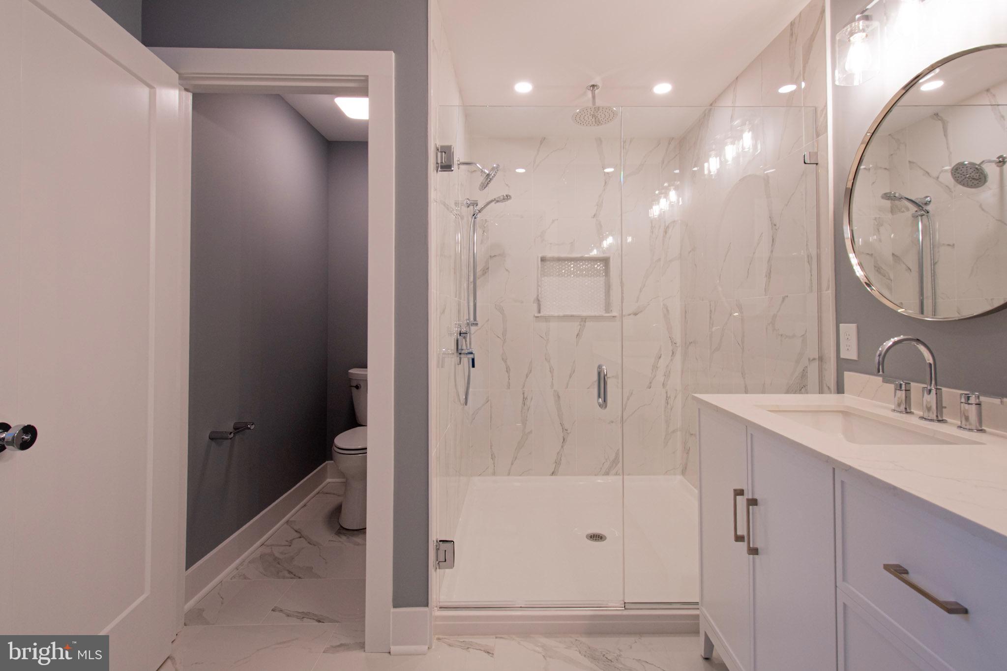 21 Manor Road Paoli, PA 19301 - Photo 23 of 35 a bathroom with a mirror a sink and a shower