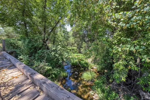 an aerial view of a houses with a lush green hillside