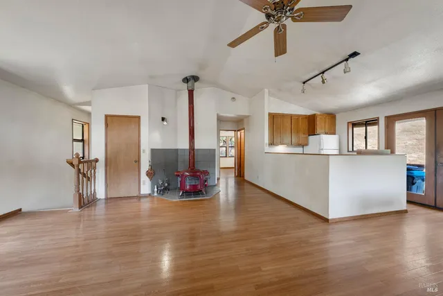 a view of a livingroom with a furniture wooden floor and a kitchen