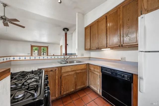 a kitchen with a stove sink and cabinets