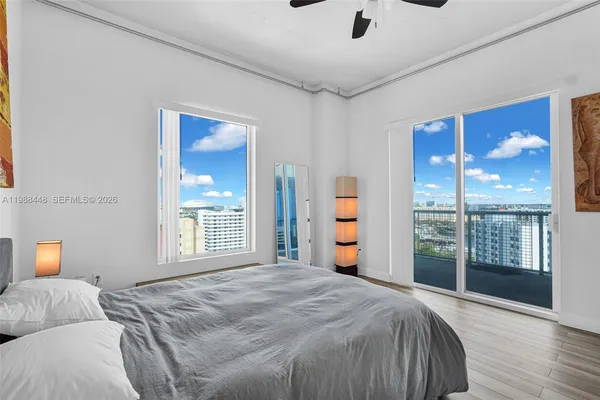 a bedroom with a large bed and a large window