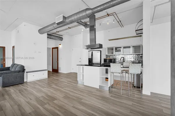 a kitchen with stainless steel appliances kitchen island hardwood floor and a window