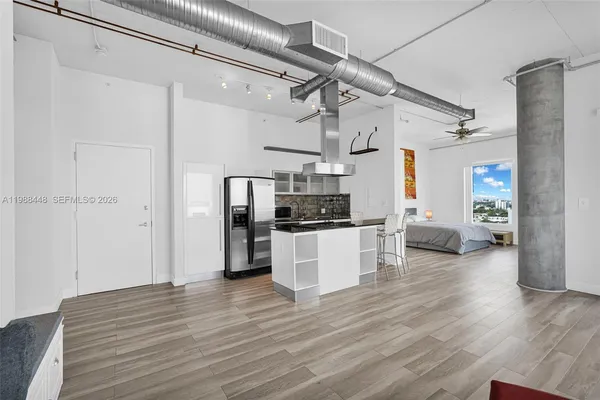 a kitchen with a refrigerator and white cabinets