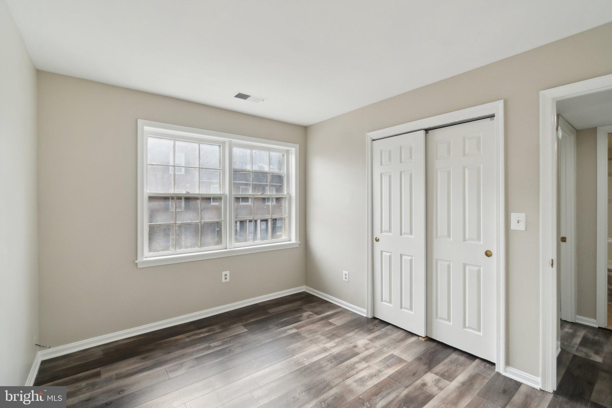 2016 37th Street Southeast, Unit 201 Washington, DC 20020 - Photo 14 of 17 an empty room with wooden floor and windows