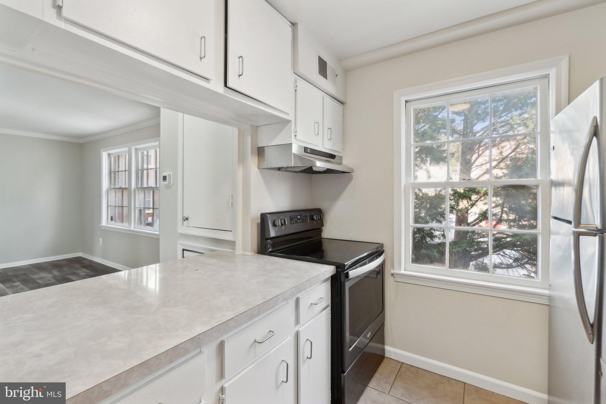 2016 37th Street Southeast, Unit 201 Washington, DC 20020 - Photo 4 of 17 a kitchen with kitchen island a stove a sink and a window