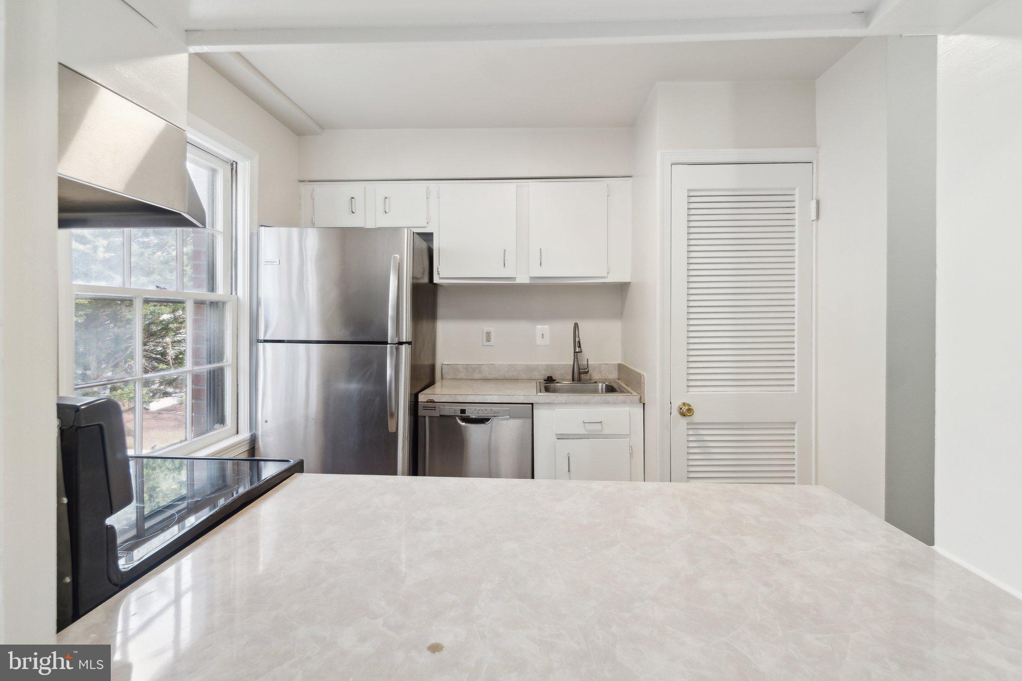 2016 37th Street Southeast, Unit 201 Washington, DC 20020 - Photo 5 of 17 a kitchen with a refrigerator a stove a sink dishwasher a refrigerator with wooden floor