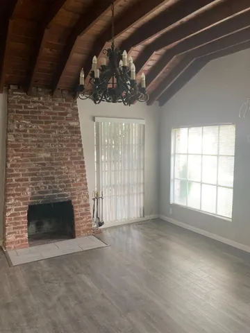 a view of an empty room with a fireplace and window