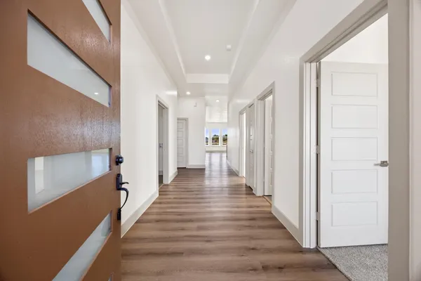 a view of a hallway with wooden floor and staircase