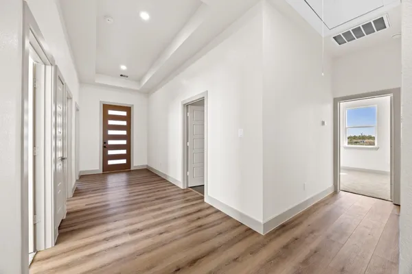 a view of a hallway with wooden floor and closet