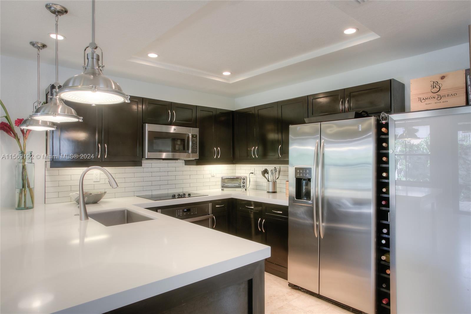 3053 Indiana Street, Unit 12 Miami, FL 33133 - Photo 11 of 23 a kitchen with stainless steel appliances a sink a stove a refrigerator and cabinets