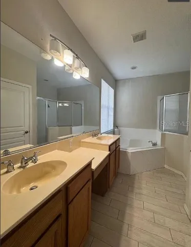 a bathroom with a granite countertop bathtub sink and mirror