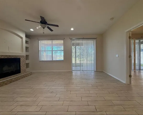a view of an empty room with a window and fireplace