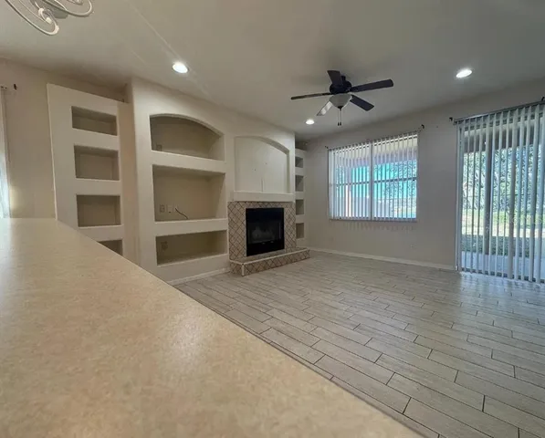 an empty room with windows and fireplace