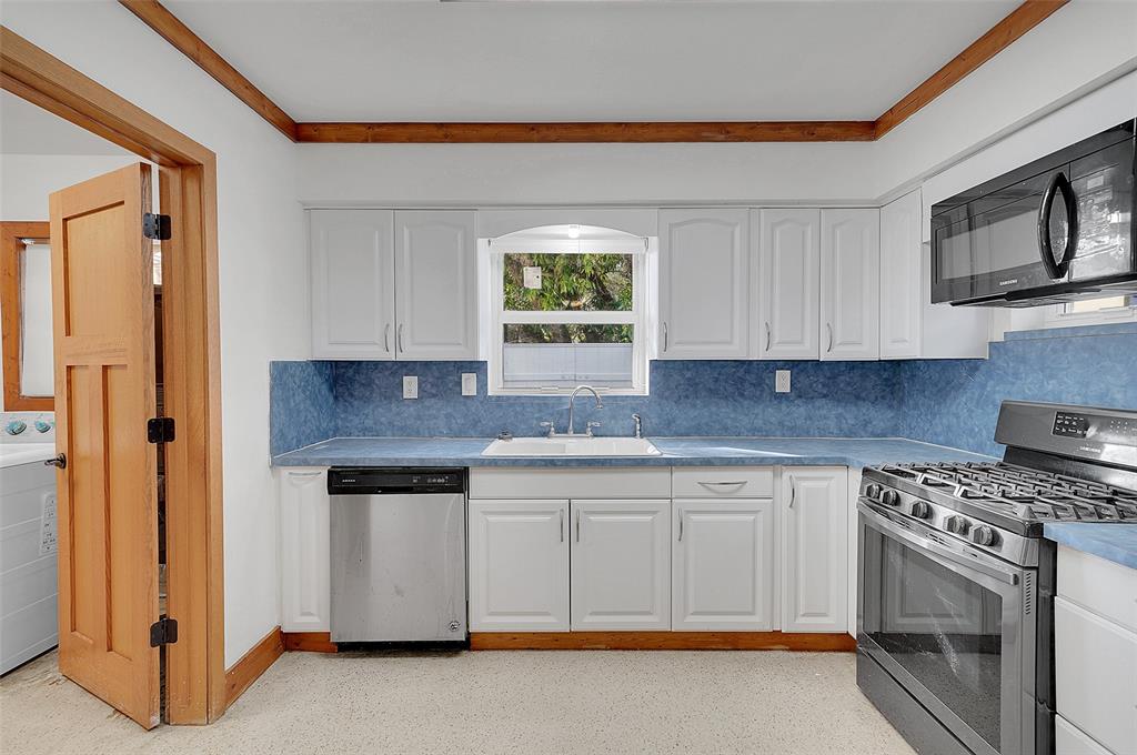 29 Southeast 8th Street Dania Beach, FL 33004 - Photo 15 of 42 a kitchen with stainless steel appliances granite countertop a stove a sink and a microwave