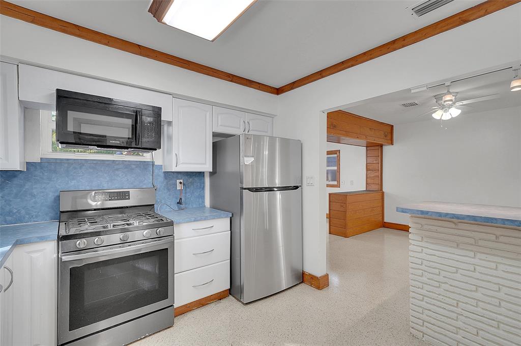 29 Southeast 8th Street Dania Beach, FL 33004 - Photo 17 of 42 a kitchen with stainless steel appliances a stove microwave and refrigerator