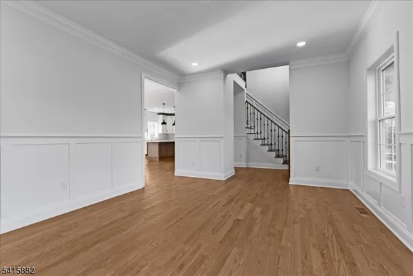 a view of empty room with wooden floor and windows