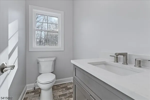 a bathroom with a toilet sink vanity and mirror