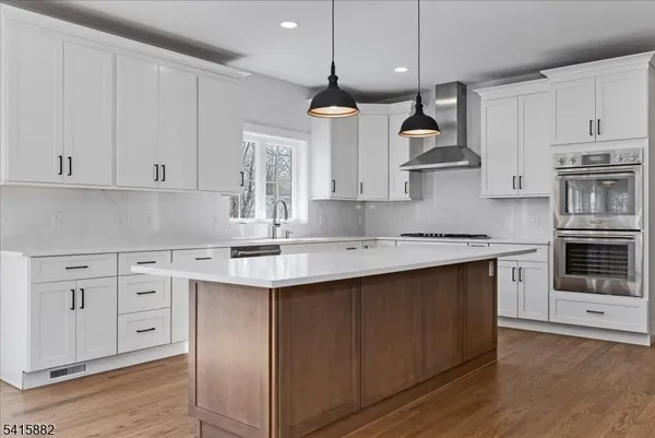 a kitchen with stainless steel appliances granite countertop a sink a stove and a refrigerator