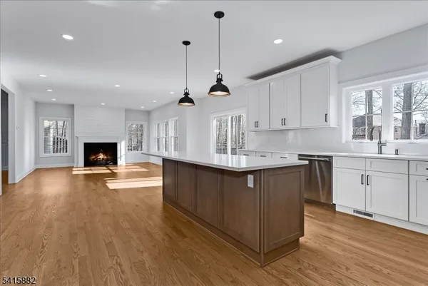 a kitchen with kitchen island a stove a sink a center island and wooden floor