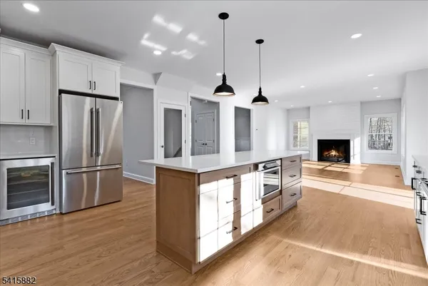 a large kitchen with stainless steel appliances kitchen island granite countertop a stove a refrigerator a oven and a wooden cabinets